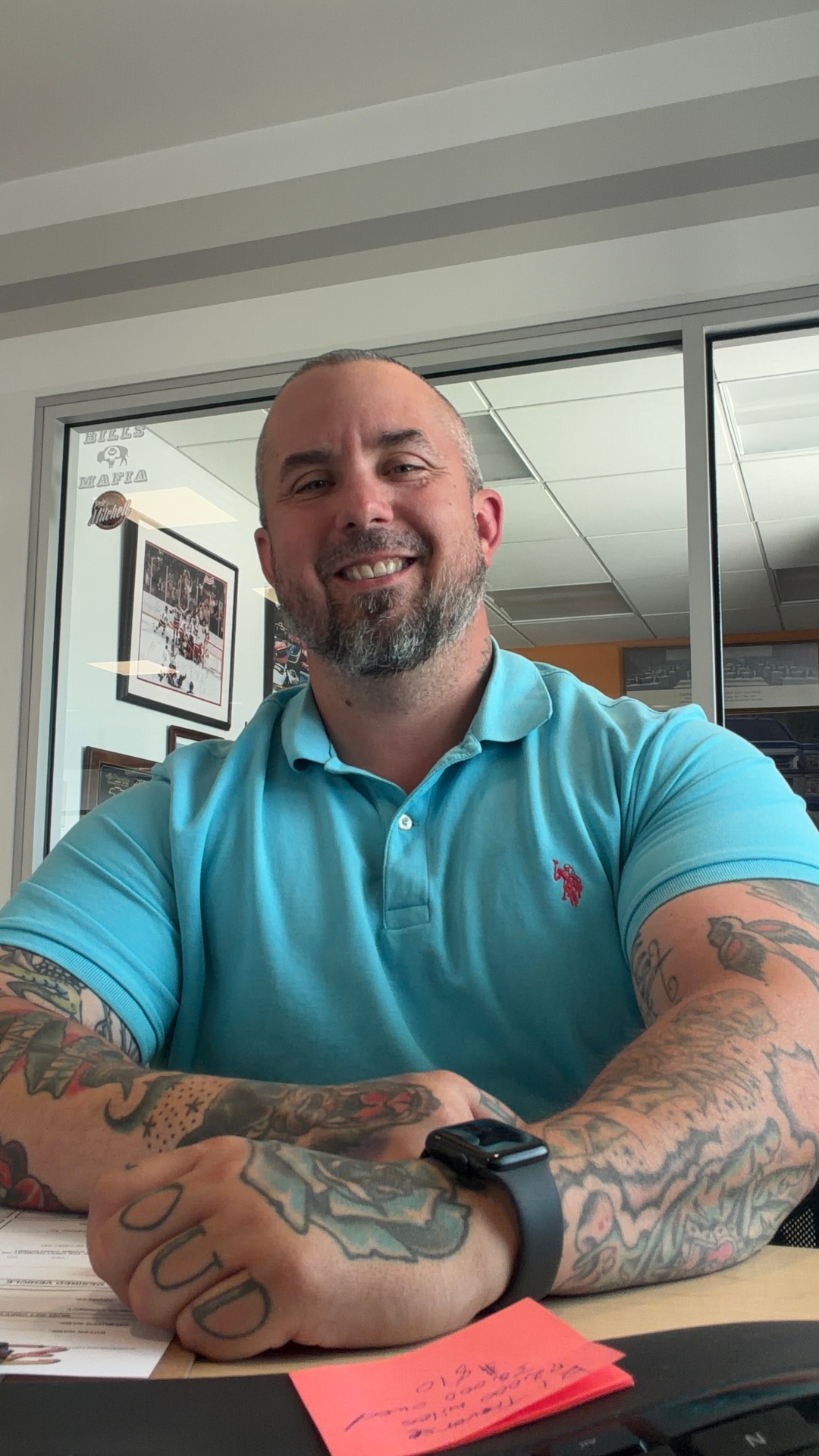 Corey Rush at his desk in teal polo